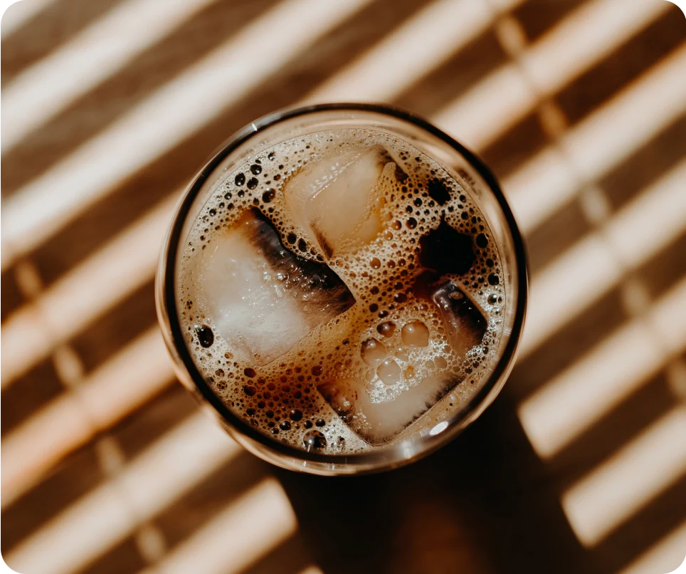 Break Coffee Cold Brew 1 A cup of iced coffee sitting on a piece of furniture, shown from above.